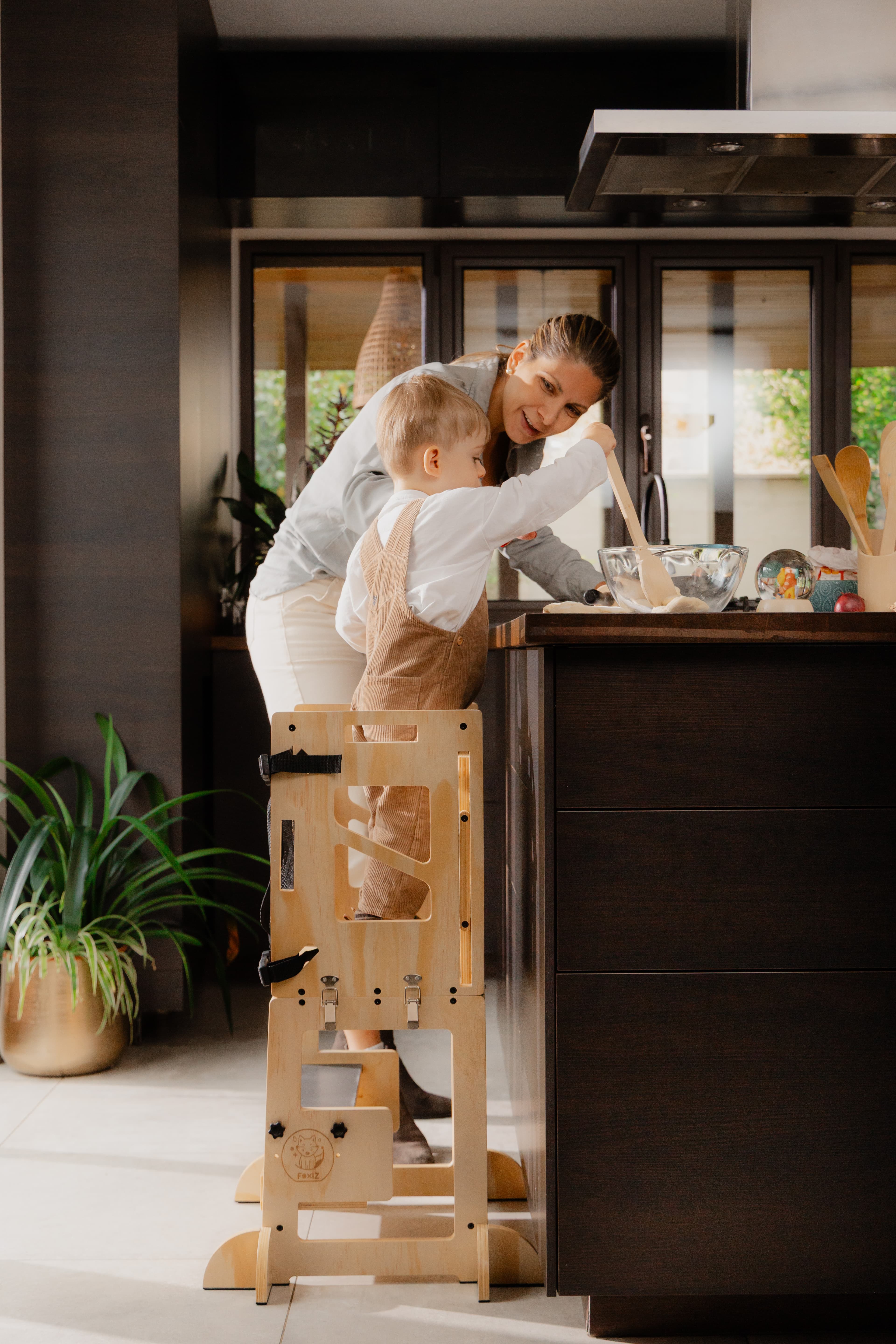 Parent et enfant cuisinant côte à côte grâce à la tour Montessori VersaTower