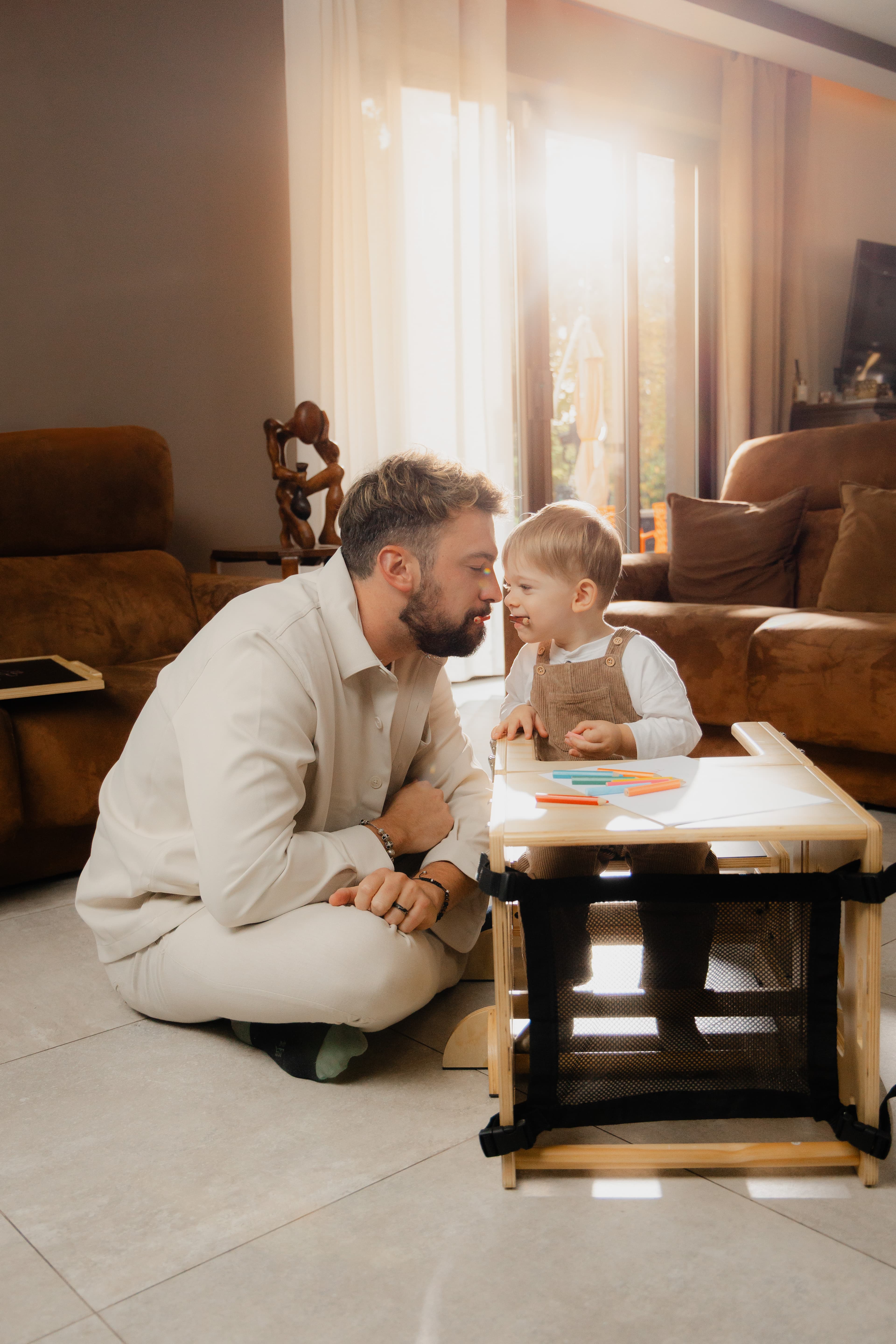 Papa et enfant attablés sur la VersaTower Montessori transformée en table et banc