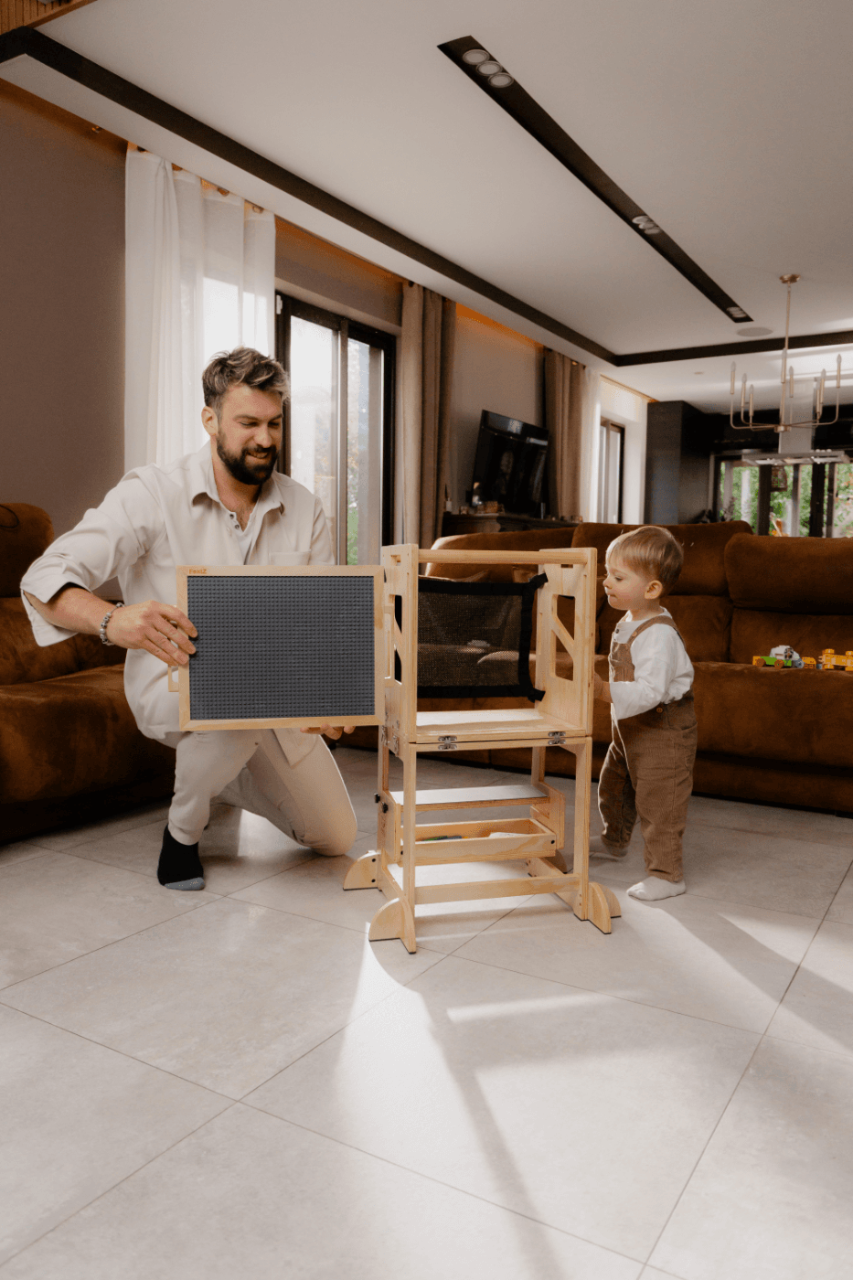 Adulte transformant une tour d'apprentissage en bois en table et chaise pour enfant