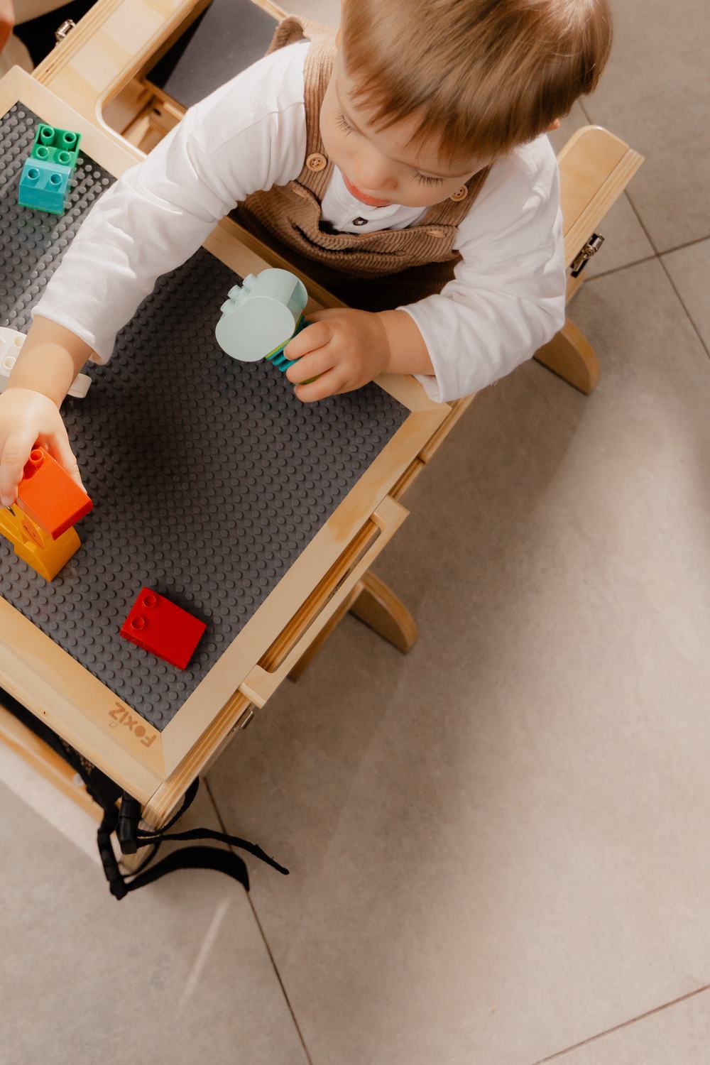 Enfant jouant avec des briques de construction sur le plateau réversible de la VersaTower